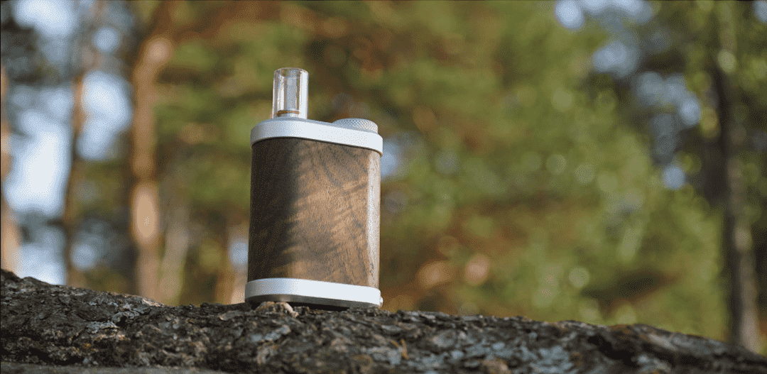 Vaporisateur Tinymight 2 en bois et acier inoxydable posé sur une surface sombre